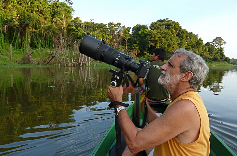 Marigo com Nikon D7000 e VR300mm f:2.8 com TC-17 no monopé, numa canoa no Mamirauá, fotografado por Cecília Banhara Marigo com Panasonic DMC-ZS7 a 4,1mm e 1/30 sec f:6,3 e ISO 100.
