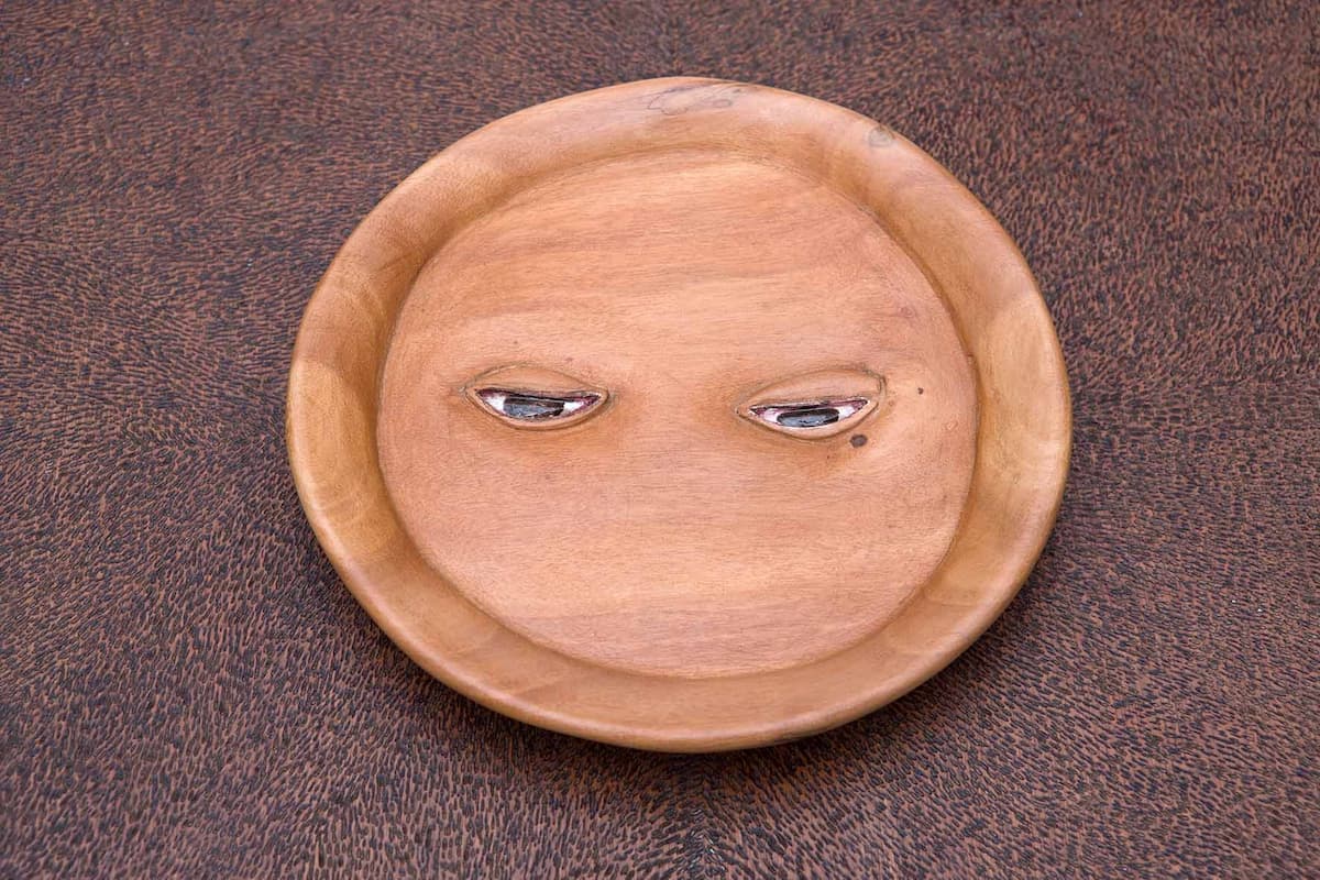 Artist: Efrain Almeida. Title: sad eyes (detail). Year: 2008. Technique: Umburana, table, oil and pyrography. Dimensions: Prato : 3 x 18 cm Ø Mesa: 66 x 50,5 x 50,5 cm. Photo: Disclosure.